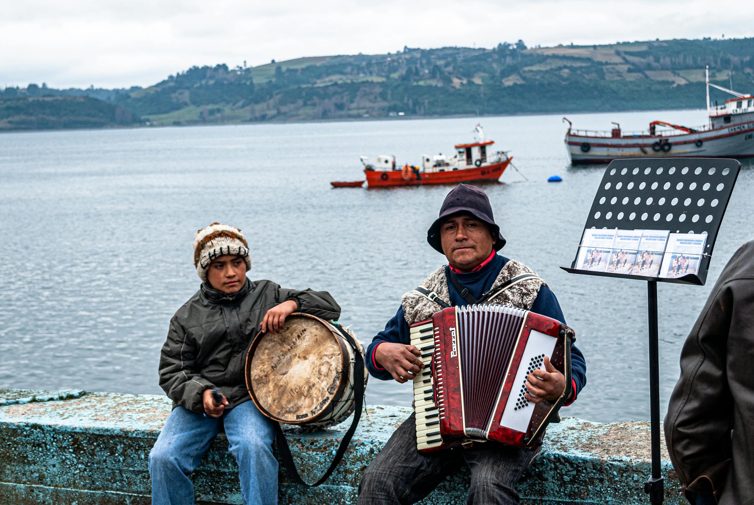 Street musicians playing accordion and drum by the lake in Los Lagos, Chile.